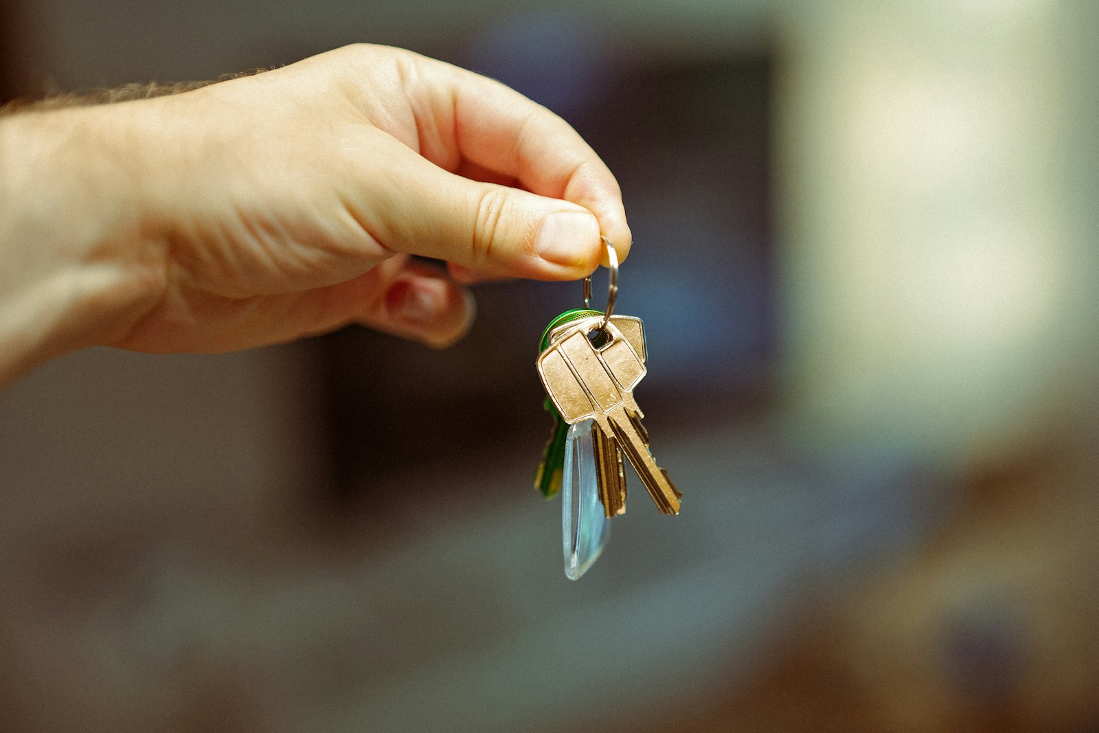 A hand holding a set of keys, representing custody passed by lease. Photo by Jakub Zerdzicki on Unsplash, used under the free Unsplash License.